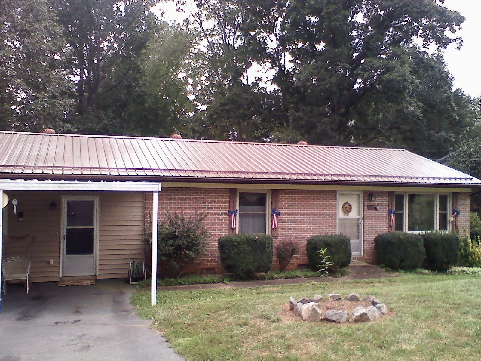 Bronze metal roof and carport on a brick ranch home — Roof Repair work by our crew in Iron City